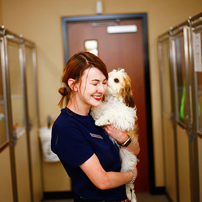 team member smiling with dog
